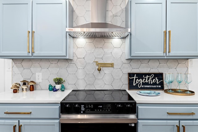 kitchen with electric stove, decorative backsplash, and wall chimney exhaust hood