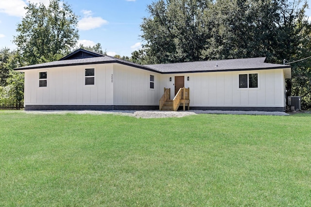 back of property with a lawn and central air condition unit