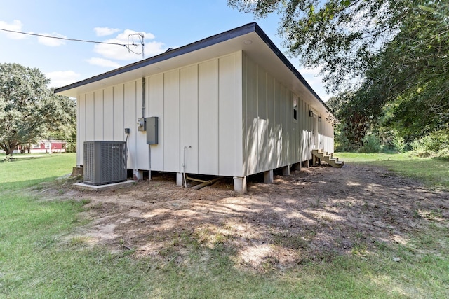 exterior space featuring central air condition unit and a yard