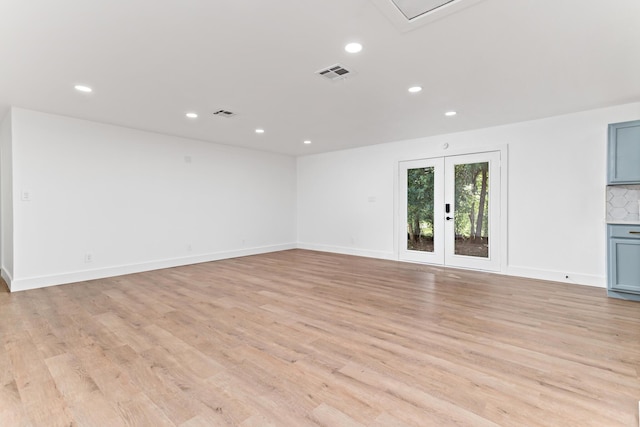 empty room featuring light wood-type flooring and french doors