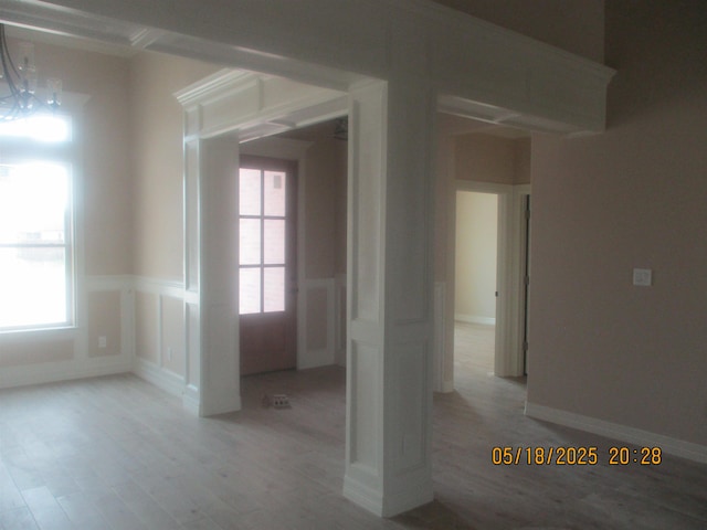 9145 Bellflower St, Beaumont, TX 77713 - empty room featuring light wood-type flooring, a wainscoted wall, a chandelier, and a decorative wall