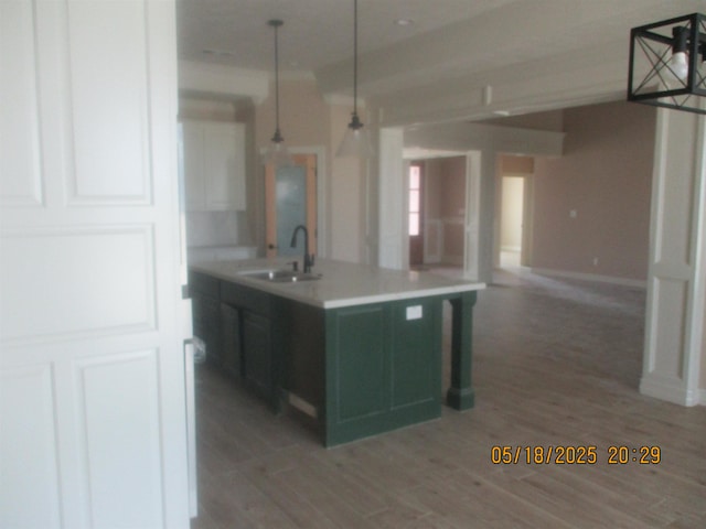9145 Bellflower St, Beaumont, TX 77713 - kitchen featuring a sink, light countertops, decorative light fixtures, and an island with sink