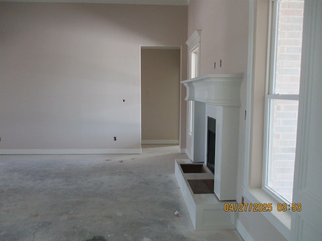 9145 Bellflower St, Beaumont, TX 77713 - unfurnished living room featuring concrete floors, healthy amount of natural light, and a fireplace