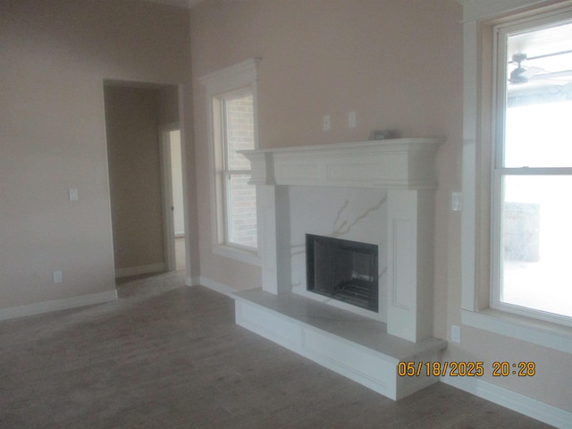 9145 Bellflower St, Beaumont, TX 77713 - unfurnished living room featuring a high end fireplace, wood finished floors, and baseboards