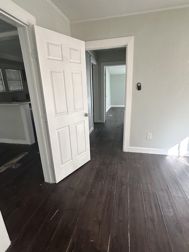 interior space featuring dark wood-type flooring, lofted ceiling, and ornamental molding