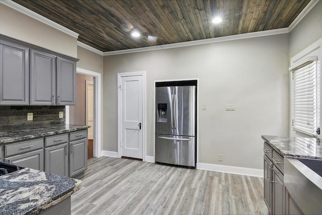 kitchen featuring wood ceiling, stainless steel fridge with ice dispenser, backsplash, and dark stone counters