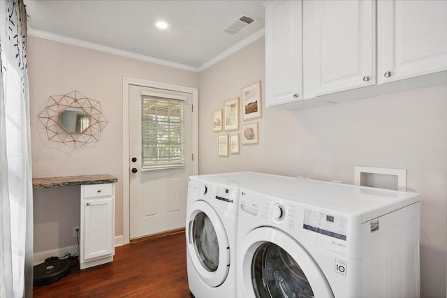 washroom with crown molding, dark hardwood / wood-style flooring, cabinets, and washer and dryer