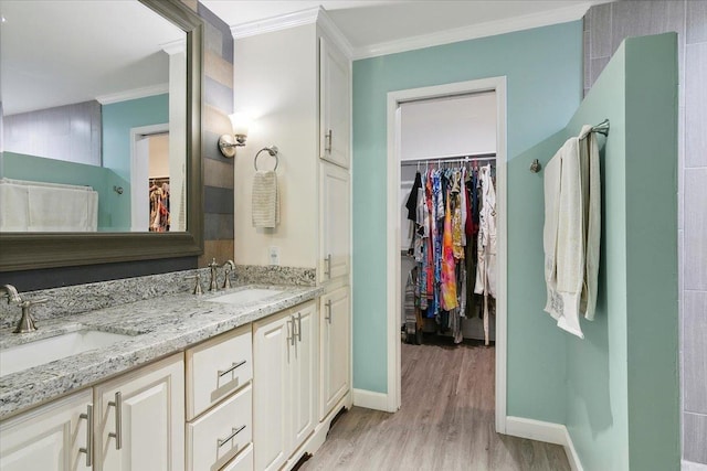 bathroom with vanity, wood-type flooring, and crown molding