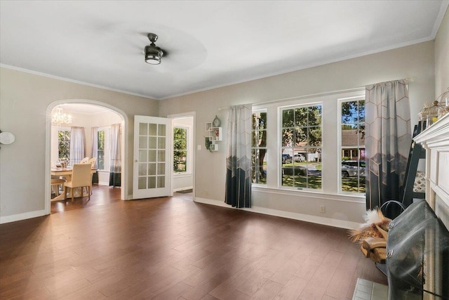 spare room with crown molding, dark hardwood / wood-style flooring, a healthy amount of sunlight, and ceiling fan with notable chandelier