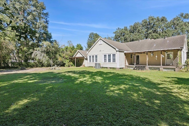 back of property featuring a lawn, covered porch, and central air condition unit