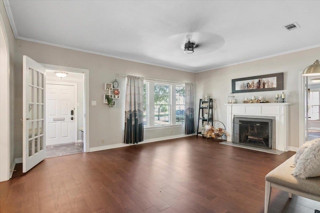 unfurnished living room featuring ornamental molding, ceiling fan, and dark wood-type flooring