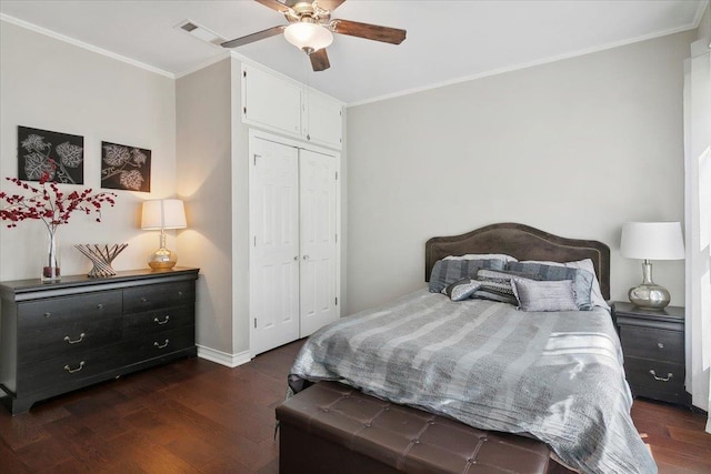 bedroom with ceiling fan, ornamental molding, dark wood-type flooring, and a closet