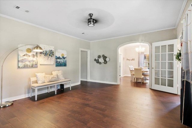 interior space featuring ceiling fan with notable chandelier, dark hardwood / wood-style flooring, and ornamental molding