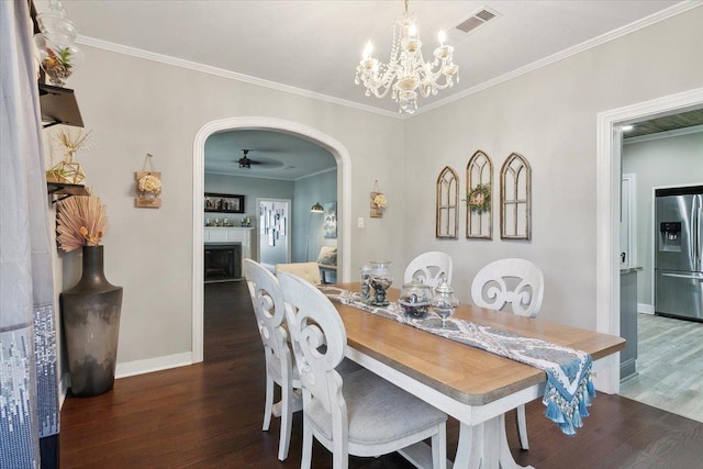 dining space with ceiling fan with notable chandelier, dark hardwood / wood-style floors, and ornamental molding