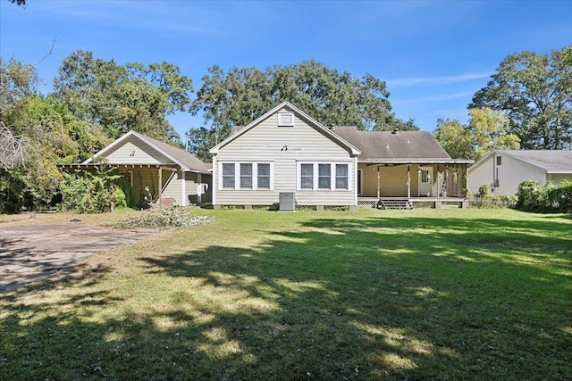 rear view of house with a porch and a yard