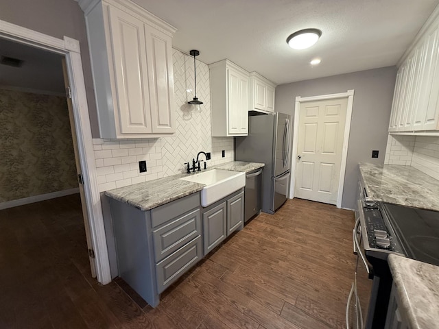 kitchen with sink, white cabinets, pendant lighting, and appliances with stainless steel finishes