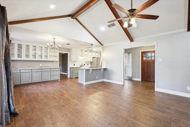 unfurnished living room with high vaulted ceiling, dark hardwood / wood-style floors, ceiling fan with notable chandelier, and beam ceiling