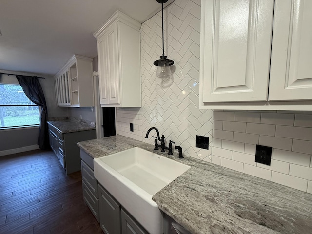 kitchen with white cabinets, dark hardwood / wood-style flooring, decorative light fixtures, and sink