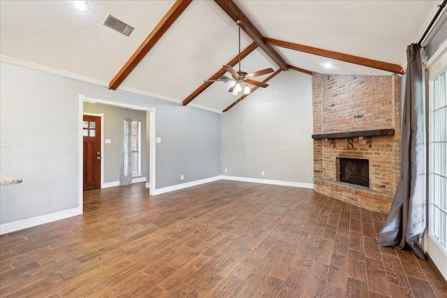 unfurnished living room featuring vaulted ceiling with beams, dark hardwood / wood-style flooring, ceiling fan, a brick fireplace, and a healthy amount of sunlight