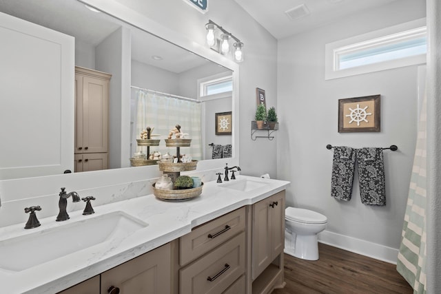 109 Ocean View Dr, Crystal Beach, TX 77650 - bathroom featuring wood finished floors, a wealth of natural light, toilet, and a sink
