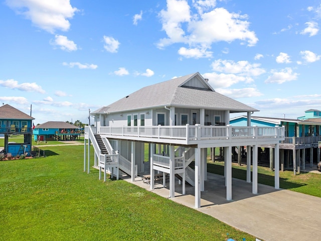 109 Ocean View Dr, Crystal Beach, TX 77650 - rear view of house with roof with shingles, concrete driveway, stairs, and a patio