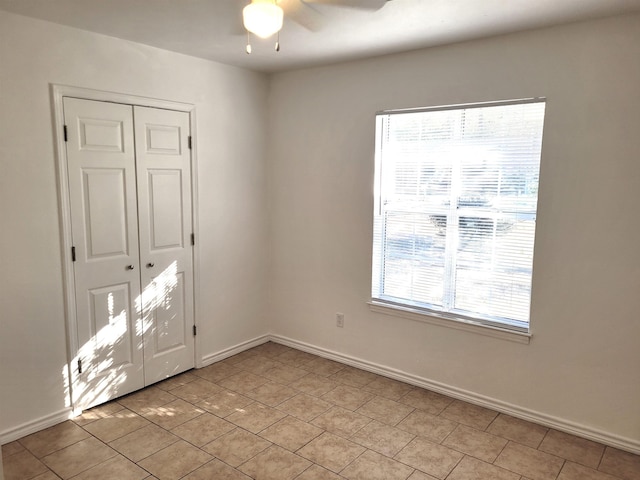 tiled spare room with ceiling fan and plenty of natural light