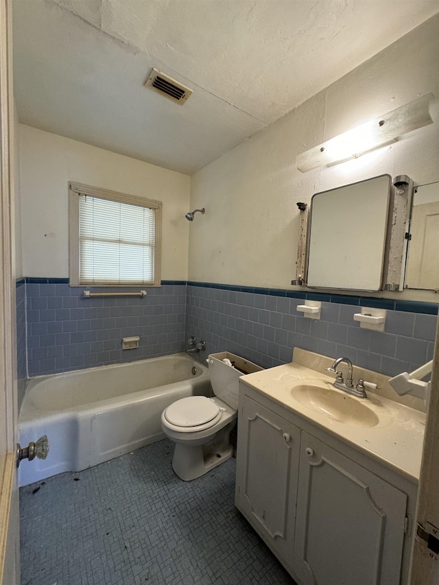 full bathroom featuring tile patterned flooring, vanity, toilet, and washtub / shower combination