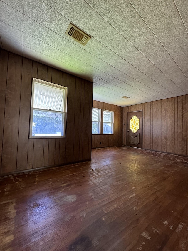 entryway with dark hardwood / wood-style floors and wood walls