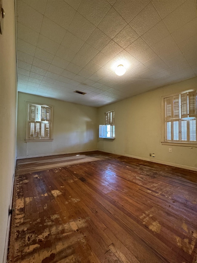 empty room with a wealth of natural light and wood-type flooring