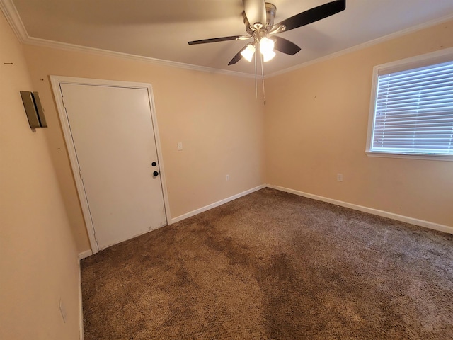 empty room with dark colored carpet, ceiling fan, and ornamental molding