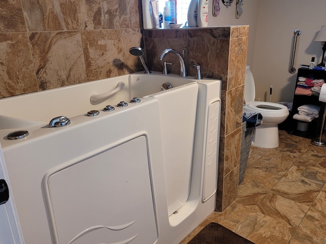 bathroom featuring a washtub and toilet