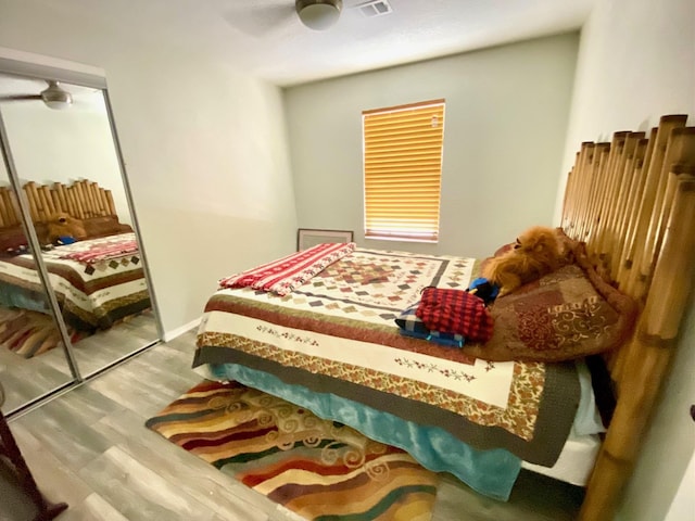 bedroom featuring hardwood / wood-style floors, ceiling fan, and a closet