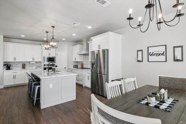 14770 Bond Rd, Beaumont, TX 77713 - kitchen with white cabinetry, appliances with stainless steel finishes, pendant lighting, and a center island with sink
