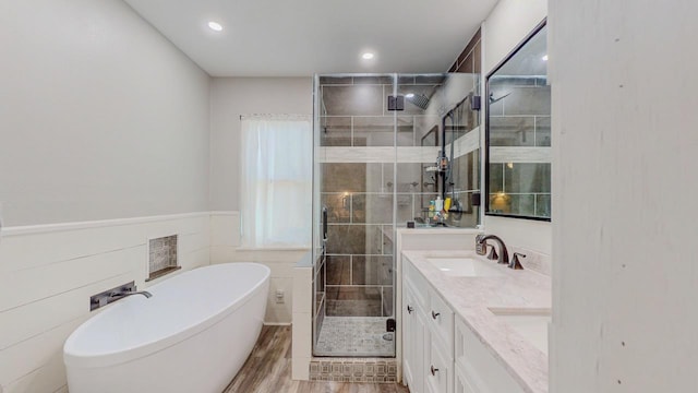 2418 Saba Ln, Port Neches, TX 77651 - bathroom with a stall shower, a soaking tub, double vanity, wood finished floors, and recessed lighting