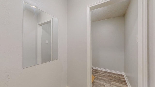 2418 Saba Ln, Port Neches, TX 77651 - hall featuring wood finished floors, a textured ceiling, and baseboards