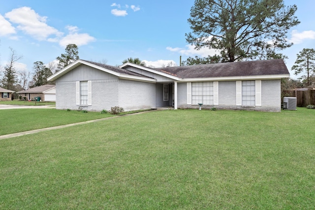 ranch-style home featuring a front yard, fence, and central AC unit