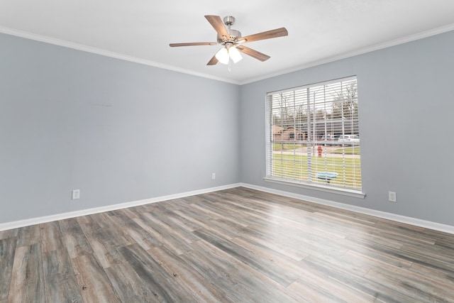 empty room featuring baseboards, wood finished floors, a ceiling fan, and crown molding