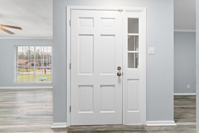 entrance foyer featuring baseboards, ornamental molding, ceiling fan, and wood finished floors