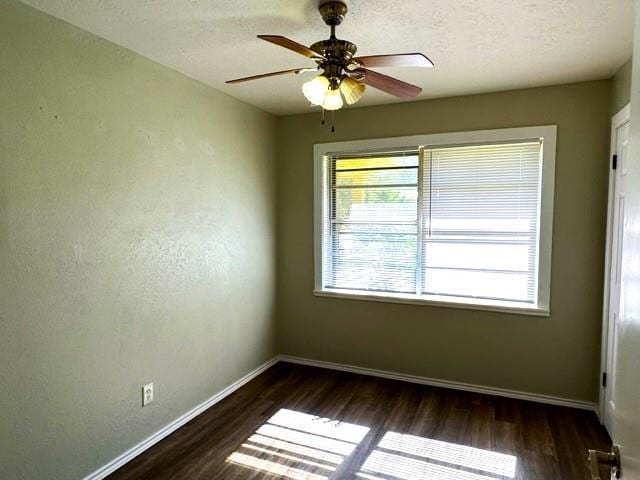 unfurnished room featuring dark hardwood / wood-style floors, ceiling fan, a textured ceiling, and a wealth of natural light