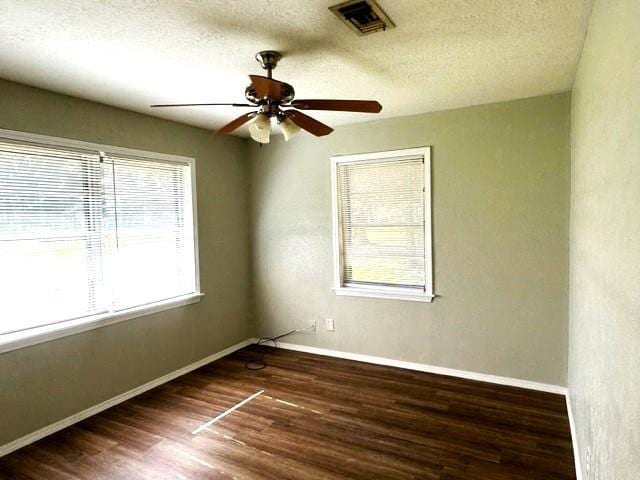 unfurnished room with a textured ceiling, ceiling fan, and dark wood-type flooring