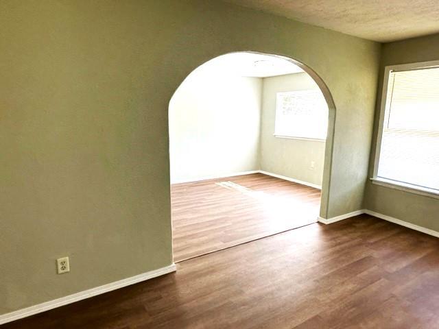 spare room featuring dark hardwood / wood-style flooring and a textured ceiling