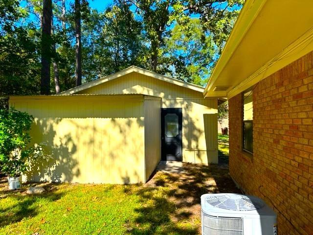 view of property exterior with a yard and cooling unit