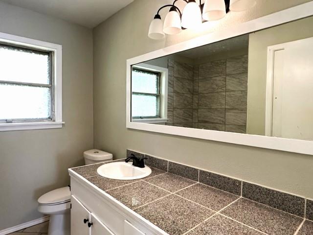 bathroom featuring tile patterned floors, vanity, and toilet