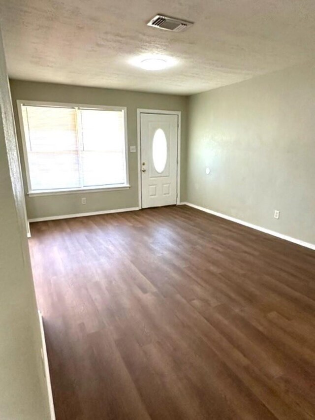 entryway with dark hardwood / wood-style flooring and a textured ceiling