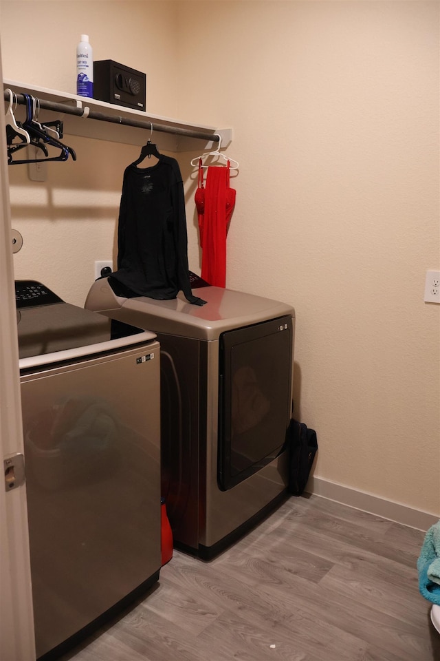 laundry area featuring washer and dryer and light hardwood / wood-style flooring