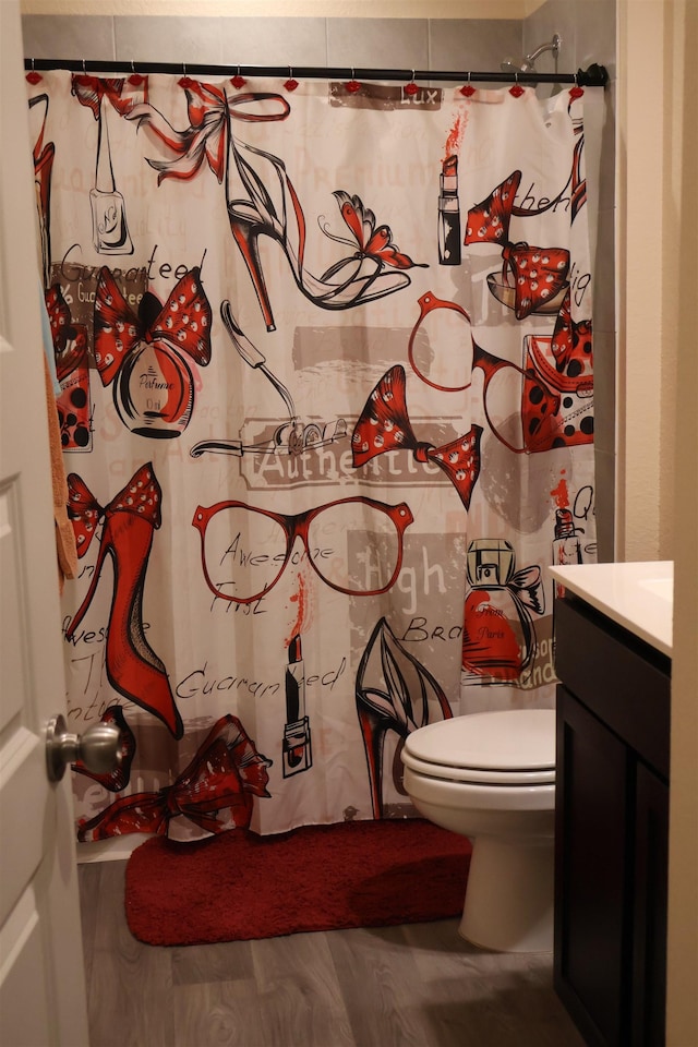 bathroom featuring a shower with curtain, wood-type flooring, vanity, and toilet