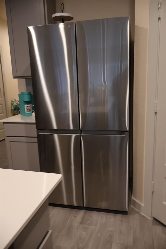 kitchen featuring gray cabinets, light hardwood / wood-style floors, and stainless steel refrigerator