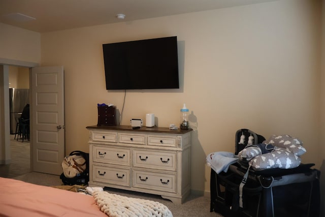 bedroom with carpet flooring and stainless steel fridge