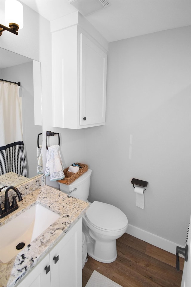 bathroom featuring vanity, toilet, and wood-type flooring