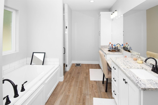 bathroom with plus walk in shower, vanity, and hardwood / wood-style flooring